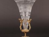 an antique glass vase with gold accents on a stand