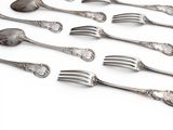 a lot of forks and spoons on a white surface
