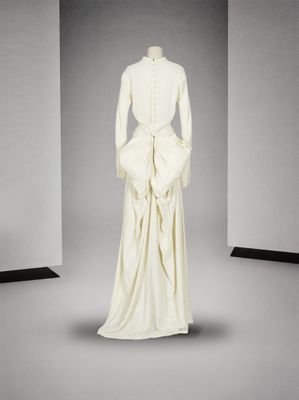 le dos d'une robe blanche ornée d'un nœud, sur un mannequin, un mannequin, un mannequin, un mannequin, un mannequin, un mannequin, un mannequin