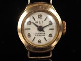 a close up of a gold wrist watch on a black surface