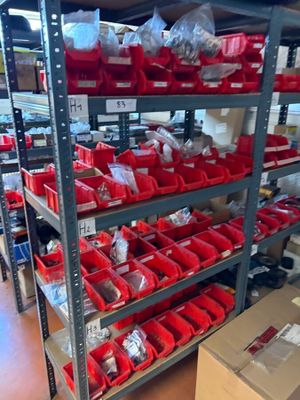 many red bins on the shelves in the warehouse