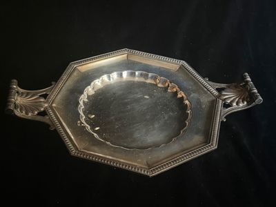 un plat ancien en argent, orné d'un motif décoratif sur fond noir