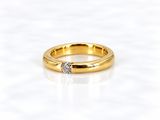 une bague en or surmontée d'un seul diamant