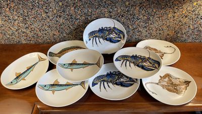 many plates with different types of fish on them on a table