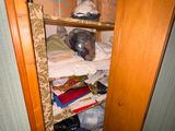 une armoire remplie de vêtements et d'autres objets