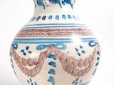 a blue and white vase sitting on a white surface
