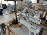 un homme debout devant une machine à coudre