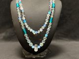 a necklace with blue and white beads on a mannequin