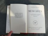 someone is holding a book open on a table with a hand on it