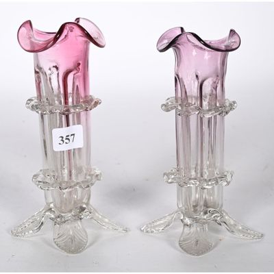 une paire de vases en verre rose posés sur une table blanche
