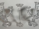 trois bougeoirs en verre posés sur une surface blanche