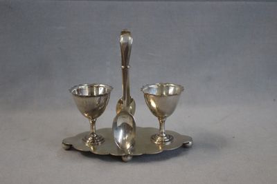 a silver plate with two spoons and two glasses on it