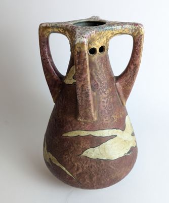 un vase marron orné d'un oiseau sur un fond blanc