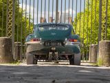 a green car that is parked in front of a gate