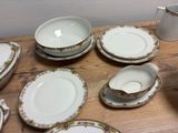 many plates and cups on a table with a pitcher