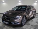 la voiture marron est garée sur un sol en damier dans le garage