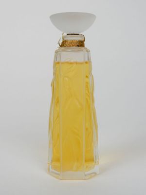 un flacon de parfum posé sur une surface blanche