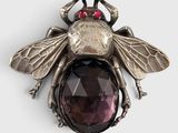 un gros plan d'une broche en forme d'abeille ornée d'une pierre facettée