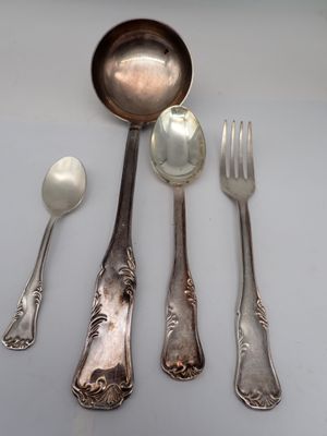 five silver spoons and two silver spoons on a table