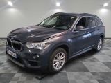 La BMW X1 est garée dans le garage, sur un sol à damier.