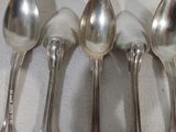 cinq cuillères alignées sur une table