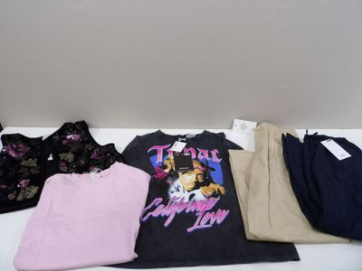 a pile of clothing on a table next to a cup of coffee