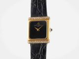 a close up of a watch on a black leather strap