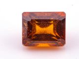 a close up of a square cut orange sapphire stone on a white surface