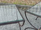 two tables with glass tops sitting on the pavement