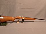 un fusil orange avec un canon en bois et une bouche verte