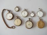 de nombreux modèles différents de montres de poche exposés sur la table