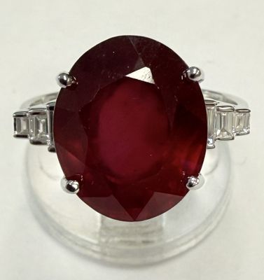 une image d'une bague ornée d'une pierre rouge entourée de pierres taillées en baguette