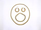 a gold necklace and earring set with a sad face