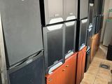 several refrigerators and freezers are lined up in a room