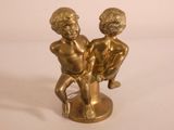 brass figurine of two children sitting on a tree stump
