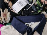 a pile of clothing on a bed with a tag on it