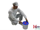 man in white coverall painting a bucket with a blue lid