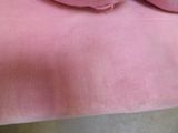a teddy bear that is laying on a pink blanket
