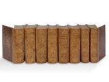 six vieux livres alignés sur une surface blanche