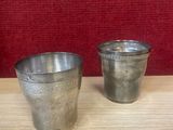 deux tasses en argent posées l'une à côté de l'autre sur une table en bois