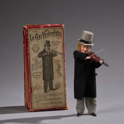 a small figurine of a man with a violin in front of a box