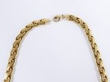 a close up of a gold chain necklace on a white background