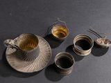 three cups and a saucer on a table