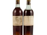 two bottles of wine sitting next to each other on a white surface