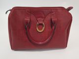 red leather handbag with a gold ring on the handle
