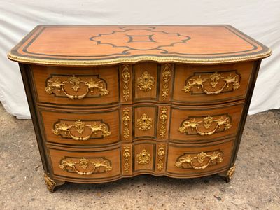 une image représentant une commode en bois ornée de motifs dorés