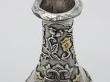 an image of a silver vase with a gold decoration on it