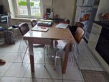 a table and chairs in a small kitchen with a window