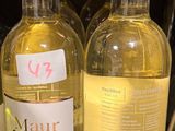 plusieurs bouteilles de vin sont alignées sur une étagère dans un magasin