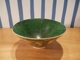 a green and white bowl sitting on a wooden table